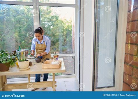 Charming Woman Housewife Amateur Florist In A Beige Apron Doing Happily Household Chores