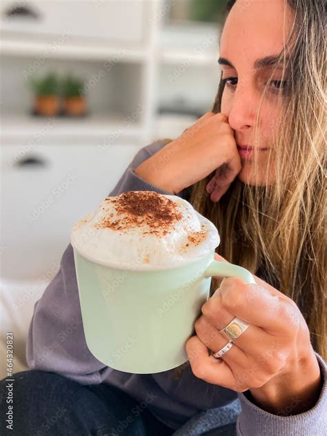 Ni A Latina Tomando Una Taza De Chocolate O Caf Caliente Y Muy Espumoso Lleva Poleron Gris