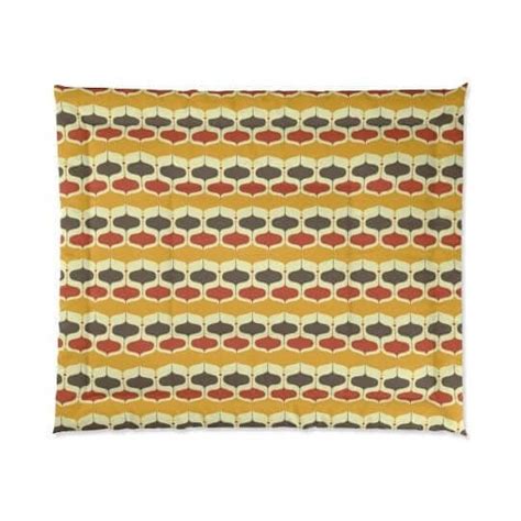 A Yellow And Brown Pillow With An Abstract Design On The Front In