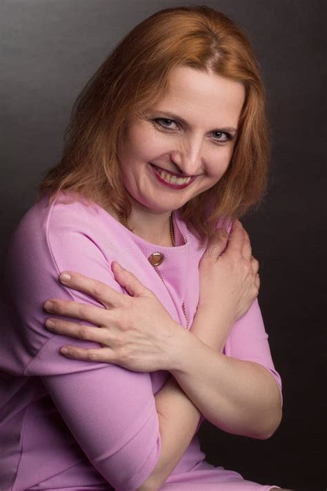 Portrait De Grand Modèle Blonde En Robe Rose Sur Fond Sombre En Studio Photo stock Image du