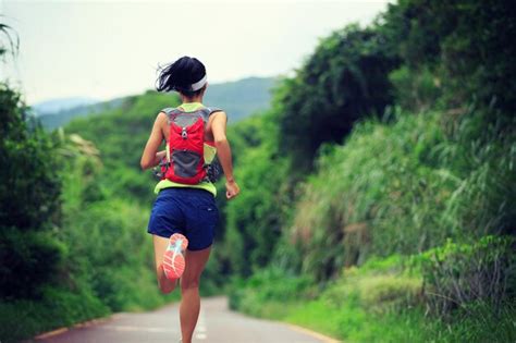 Premium Photo | Young fitness woman trail runner running in forest mountain