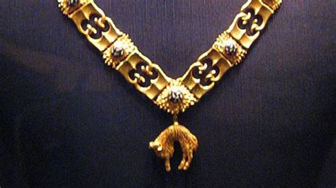 An Elaborate Gold Necklace Is Displayed On A Mannequin S Neckline