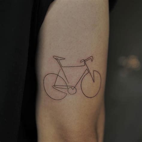 One line bicycle tattoo located on the tricep.