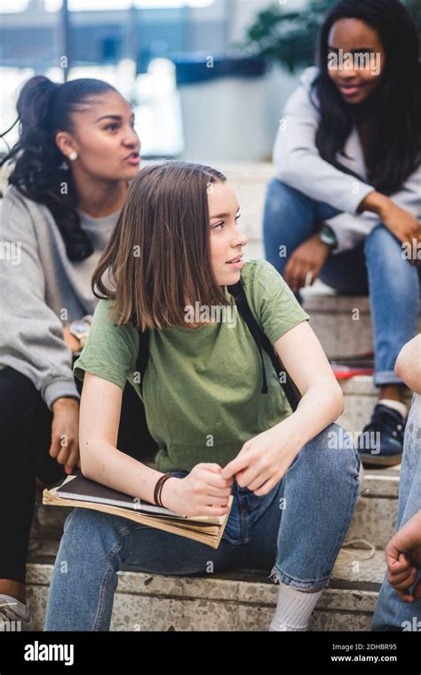 Multi Ethnic Female High School Students Sitting On Steps Stock Photo