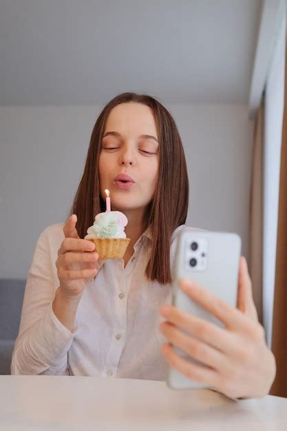 Premium Photo Attractive Woman Blowing Out The Candle On The Birthday Cake And Making Selfie