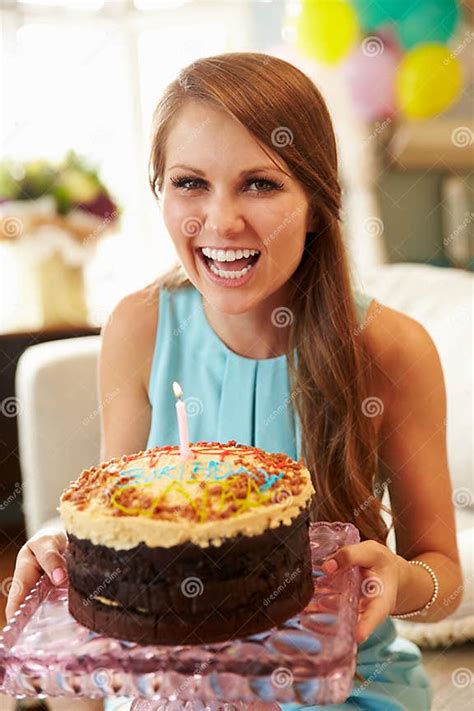 Portrait Of Young Woman Blowing Out Candle On Birthday Cake Stock Image