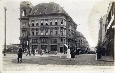 An Old Black And White Photo Of People Walking On The Street In Front