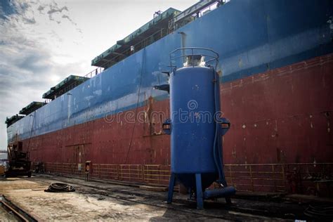 A Large Tanker Cargo Ship Is Being Renovated And Painted In Shipyard