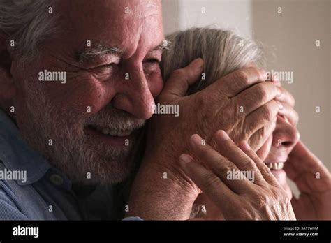 Elderly Husband Surprises His Mature Wife By Covering Her Eyes With His Hands And Hugging Her