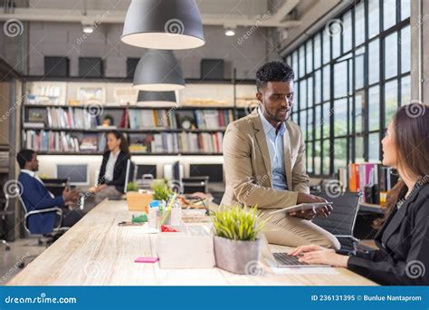 Colleagues In A Boardroom Discussion Seated At A Table Together