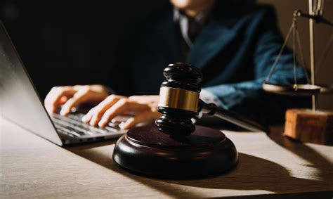 law books and scales of justice on desk in library of law firm