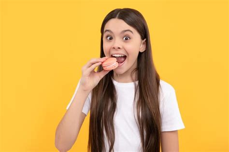 Heureux enfant manger dessert boulangerie enfant tenir français macaron