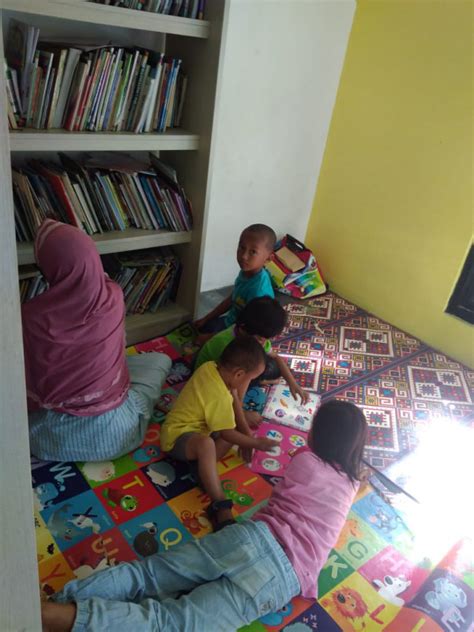 Anak - anak membaca buku di perpustakaan