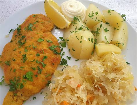 [homemade] Pork Schnitzel With Boiled Potatoes And Sauerkraut Wedge Of Lemon And Mayonnaise On