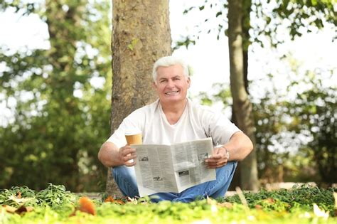 Premium Photo Handsome Mature Man Reading Newspaper In Park