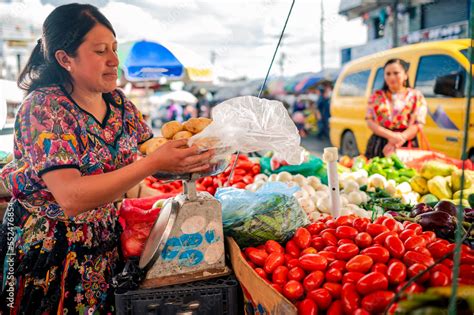 Mujer indígena vendiendo vegetales en un mercado guatemalteco Stock