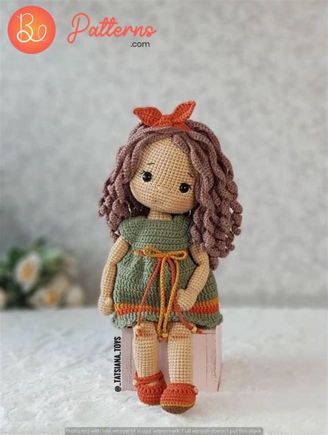 A Crocheted Doll Sitting On Top Of A Bed