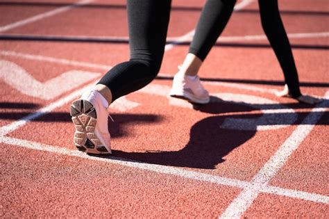 Vista Trasera Del Corredor De La Mujer En La Pista De Atletismo