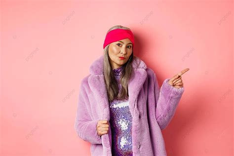 Stylish Senior Woman In Purple Coat Pointing And Sassy Photo Background