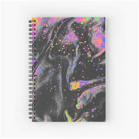 A Spiral Notebook With Colorful Paint Splattered On The Front And