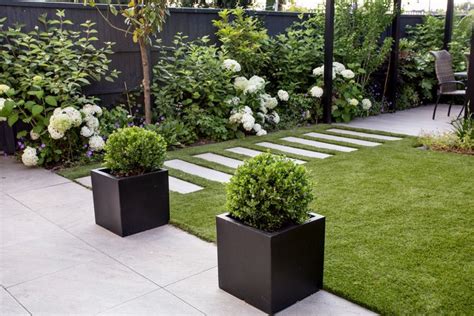 Contemporary Garden With Grass And Flowers In Black Planters