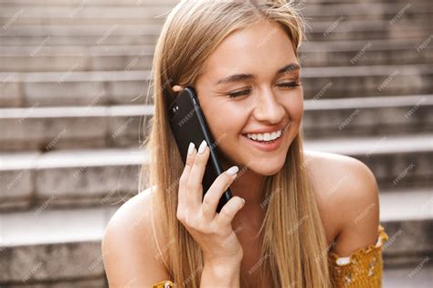 Premium Photo Beautiful Smiling Young Girl Talking On Mobile Phone While Sitting On Stairs