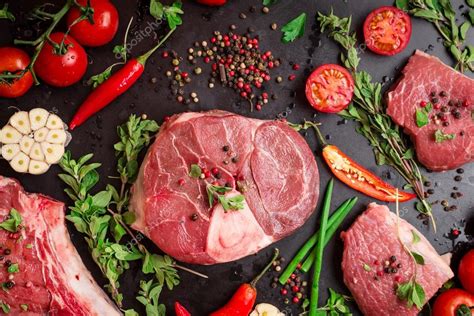 Стейки из сырого мяса на тёмном фоне, готовые к жарке стоковое фото ...