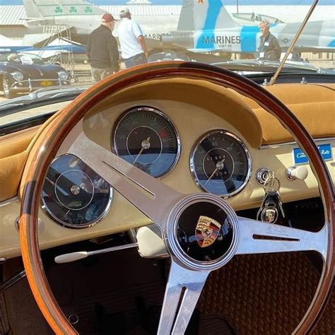 The Steering Wheel And Dashboard Of An Old Car With People Walking