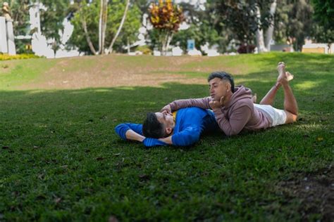 Una pareja gay tumbada en el césped de un parque con una actitud tierna Foto Premium