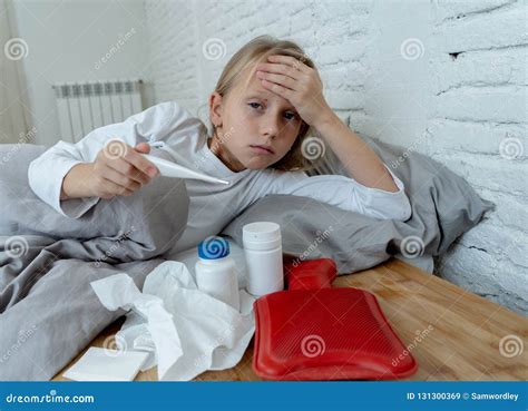 Little Girl Lying Sick In Bed Feeling Sick With High Fever And Headache