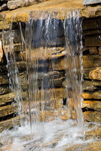 Premium Photo Small Rocky Waterfall Pouring Into A Lake