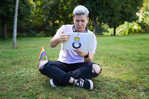 Gender Non Binary Person Is Rolled Up With The Gay Pride Flag On His Body She Is Looking At The