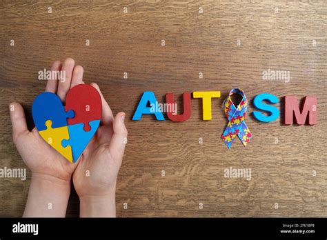 Autistic Boy Hands Holding Heart Shapeed Puzzle With Word Autism And