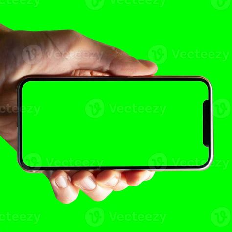 Image of hand holding a phone with a green screen in landscape ...