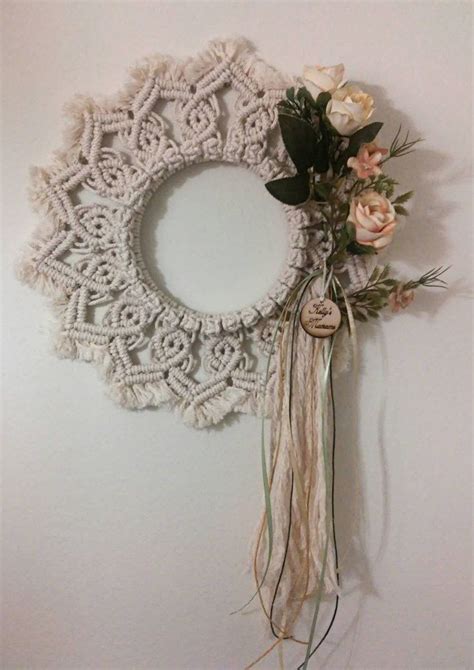 A White Doily Hanging On The Wall Next To A Flower Wreath With Flowers