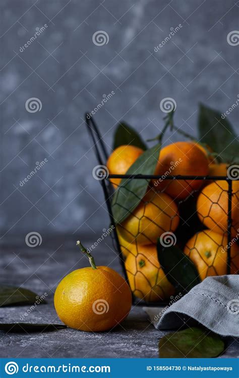 Mandarinas Frescas Con Hojas En Una Canasta Sobre Un Fondo Oscuro Foto