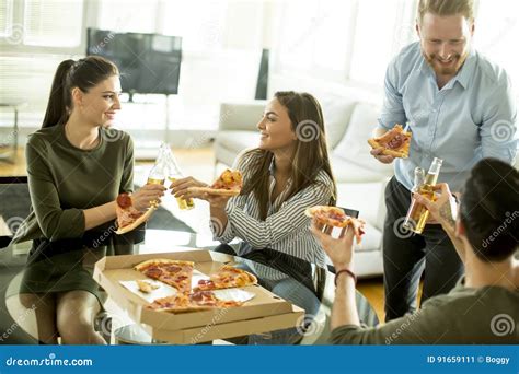 Grupo De Gente Joven Alegre Que Come La Pizza En El Cuarto Imagen De