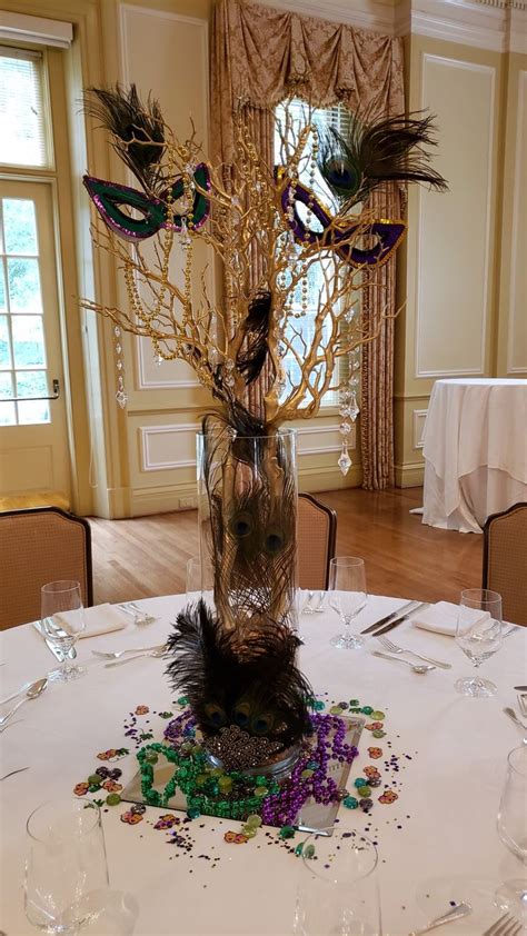 There Is A Vase With Feathers On The Table In Front Of Some Wine