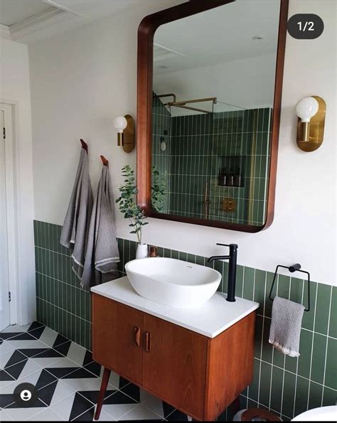 A Bathroom With Green Tiled Walls And Black And White Flooring A