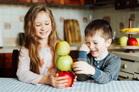 Les Enfants Mangent Des Pommes Et Ont L Amusement Dans La Cuisine Au