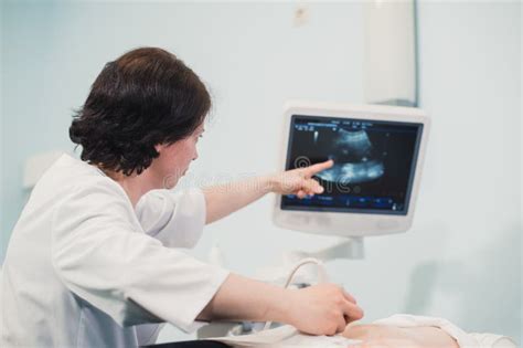 Doctor Showing Baby Ultrasound Image On Computer To Pregnant Woman