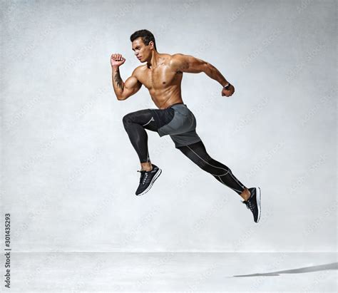 Sporty Man Jumping Photo Of Active Man With Naked Torso On Grey Background Dynamic Movement