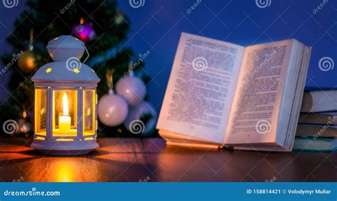 Lantern With Book And Open Book Near Christmas Tree Reading In Candle