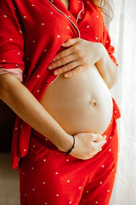 Vertical Cropped Unrecognizable Pregnant Woman Hold Naked Abdomen In Red Loose Pajamas Stand