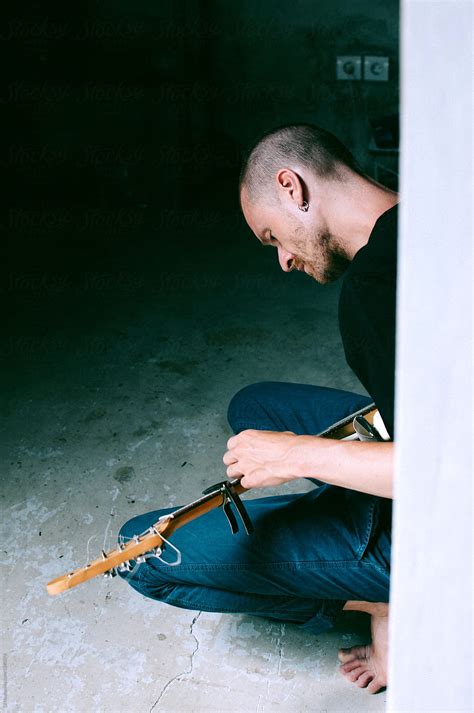 Young Man Making Music With His Guitar At Home By Stocksy Contributor