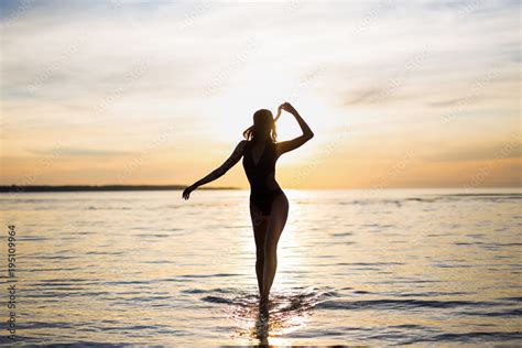 Silhouette Of Slim Sexy Woman In Bikini Walking On The Beach Stock