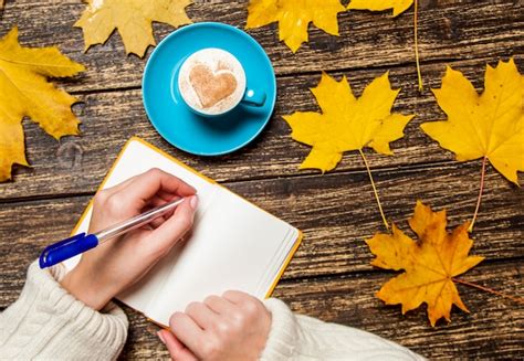 Escritura Femenina De La Mano Algo En Cuaderno Cerca De La Taza De Caf