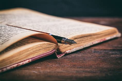 Vintage Book And Ink Pen On A Wooden Desk