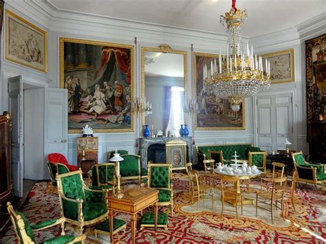 an ornately decorated living room with green velvet chairs and gold ...