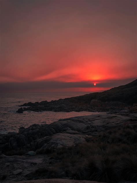 Sunset Over Rock Formation and Sea · Free Stock Photo